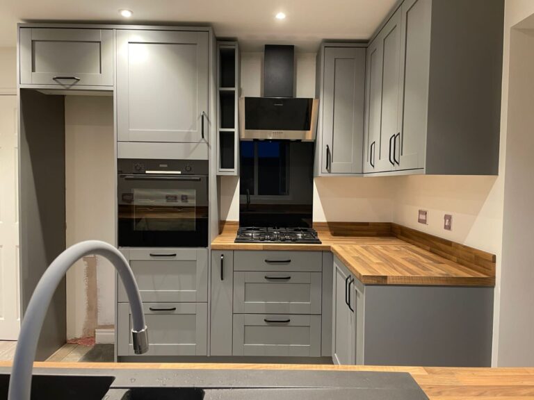 Neo Lisse kitchen viewed from behind sink towards cupboards and integrated appliances